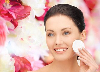 Image showing smiling woman cleaning face skin with cotton pad