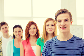 Image showing smiling students with teenage boy in front