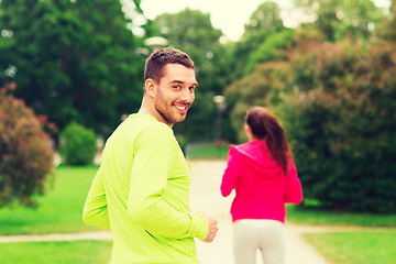 Image showing smiling couple running outdoors