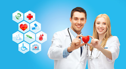 Image showing smiling doctors cardiologists with small red heart