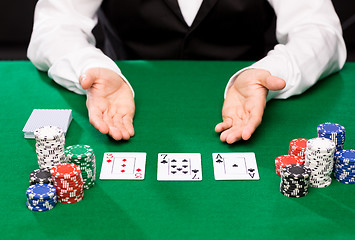 Image showing holdem dealer with playing cards and casino chips