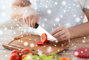 Image showing close up of man cutting vegetables with knife