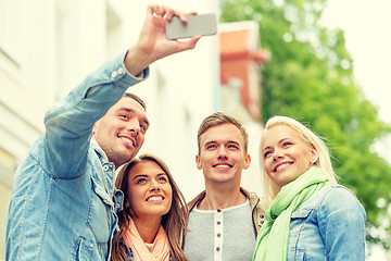 Image showing group of smiling friends making selfie outdoors