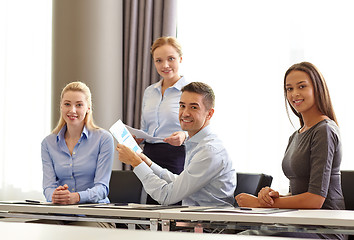 Image showing smiling business people with papers in office