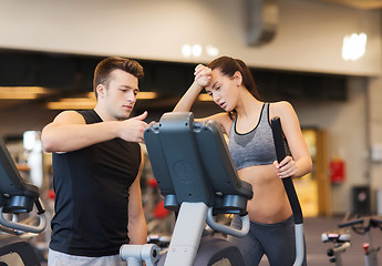 Image showing woman with trainer exercising on stepper in gym