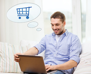Image showing smiling man with laptop shopping online at home