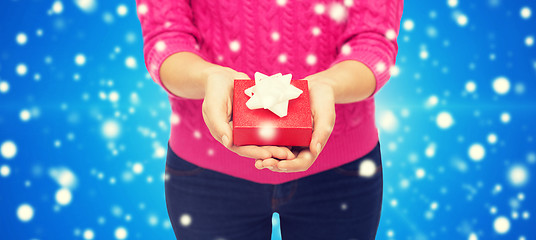 Image showing close up of woman in pink sweater holding gift box