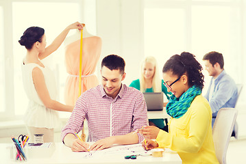 Image showing smiling fashion designers working in office