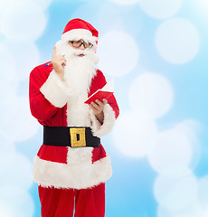 Image showing man in costume of santa claus with notepad