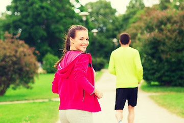 Image showing smiling couple running outdoors