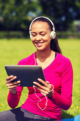 Image showing smiling woman with tablet pc outdoors