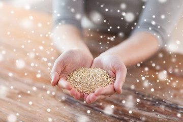 Image showing close up of female cupped hands with quinoa