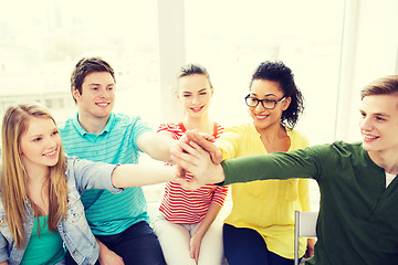 Image showing smiling students making high five gesture sitting