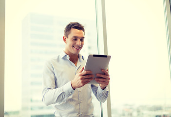 Image showing smiling businessman with tablet pc in office