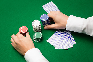 Image showing holdem dealer with playing cards and casino chips