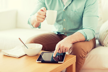 Image showing close up of man with tablet pc having breakfast