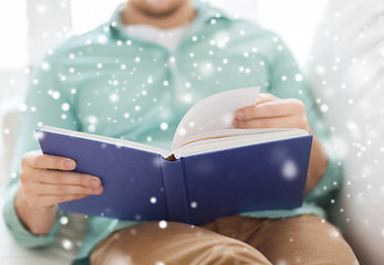 Image showing close up of man reading book at home