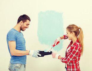 Image showing smiling couple painting wall at home