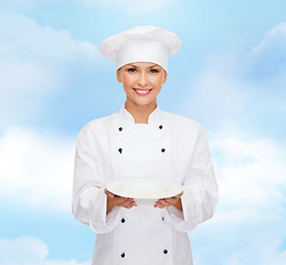 Image showing smiling female chef with empty plate