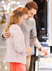 Image showing happy couple choosing engagement ring in mall