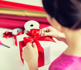 Image showing close up of woman decorating christmas presents