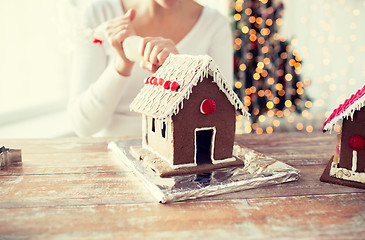 Image showing close up of woman making gingerbread houses