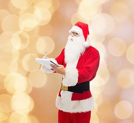 Image showing man in costume of santa claus with notepad