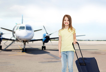 Image showing smiling girl with travel bag in airport