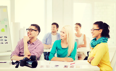 Image showing smiling team with photocamera working in office