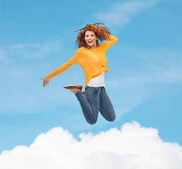 Image showing smiling young woman jumping in air