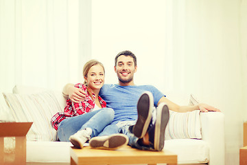 Image showing smiling couple relaxing on sofa in new home