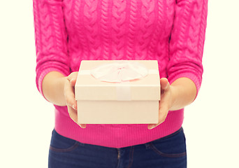 Image showing close up of woman in pink sweater holding gift box