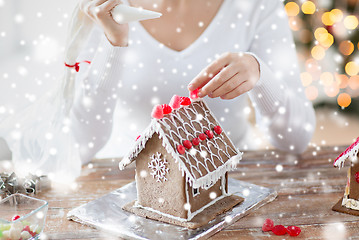 Image showing close up of woman making gingerbread houses