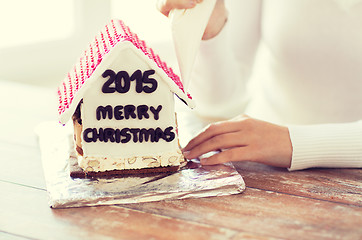 Image showing close up of woman making gingerbread houses