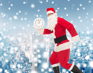 Image showing man in costume of santa claus with clock