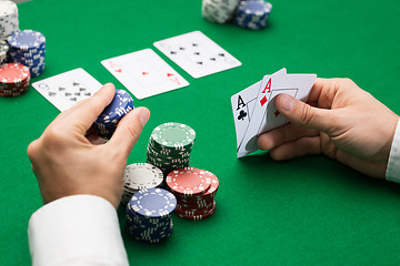 Image showing poker player with cards and chips at casino