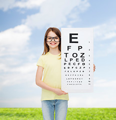 Image showing little girl in eyeglasses with eye checking chart