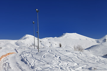 Image showing Winter mountains and ski slope at nice sun day