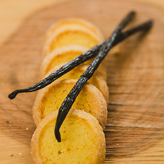 Image showing Fresh baked shortbread cookies with  with vanilla sticks on a wood