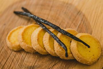 Image showing Fresh baked shortbread cookies with  with vanilla sticks on a wood