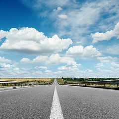 Image showing asphalt road with white line on center close up under cloudy sky