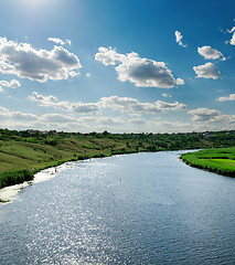 Image showing view to river with reflection under blue cloudy sky and sun