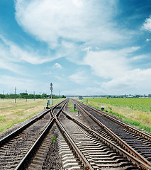 Image showing crossing of railroad to horizon under cloudy sky