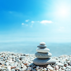 Image showing zen-like stones on beach and sun in sky