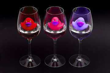 Image showing Red, pink and purple rubber ducks in wineglasses