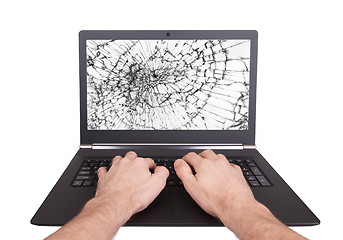 Image showing Man working on a laptop with a broken screen