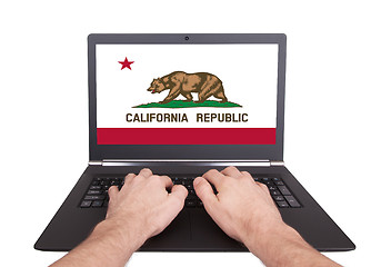 Image showing Hands working on laptop, California