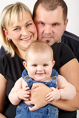 Image showing Loving mother and father embracing her baby girl