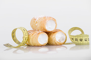 Image showing concept of slimming, cakes with measuring tape