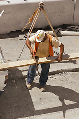 Image showing Builder with a hand saw